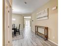 Open-concept foyer with wood-look tile flooring, console table, and view to the dining and living areas at 6897 Linda Creek Ct, Las Vegas, NV 89178