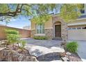 Inviting stone accented entrance featuring mature landscaping and a stone walkway at 7033 Twin Forks Peak St, Las Vegas, NV 89166
