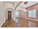 Spacious formal living room with hardwood floors, an elegant chandelier, and large windows with plantation shutters at 7033 Twin Forks Peak St, Las Vegas, NV 89166