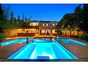 Backyard oasis with a large pool, in-pool lighting, outdoor bar, and well-manicured greenery at 7033 Twin Forks Peak St, Las Vegas, NV 89166