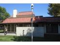 Back exterior with brick details, covered patio, tiled roof, and green grass at 761 Bourbon St # 5, Pahrump, NV 89048
