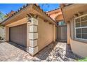 Stunning front entry featuring a two-car garage, stylish pillars and an arched walkway to the double door entryway at 7998 Base Camp Ave, Las Vegas, NV 89178