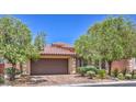 Inviting single-Gathering home showcasing a two-car garage, paver driveway, and mature trees for curb appeal at 7998 Base Camp Ave, Las Vegas, NV 89178