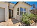 Close-up view of the front entrance showing stone accents, window, and desert landscaping at 8934 Windgate Ranch St, Las Vegas, NV 89166