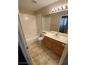 Standard bathroom features a tub and shower combination, tile floor, and a wood vanity with a sink at 8959 Coral Shale St, Las Vegas, NV 89123