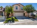 Two-story home featuring a two-car garage, front lawn, and mature trees at 11147 Verismo St, Las Vegas, NV 89141