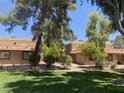Charming condo featuring a red tile roof, complemented by mature trees and a lush green lawn at 1843 Mimosa Ct, Henderson, NV 89014