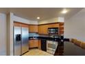 Well-lit kitchen featuring stainless steel appliances, black countertops, and ample wood cabinetry at 211 E Flamingo Rd # 202, Las Vegas, NV 89169