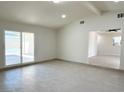 Open-concept living space with sliding glass doors leading to the backyard, complemented by sleek tile flooring at 236 Pershing Dr, Las Vegas, NV 89107