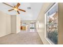 Bright living room featuring a ceiling fan, neutral carpet, and natural light at 2558 Lazy Saddle Dr, Henderson, NV 89002