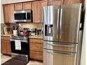 Modern kitchen featuring stainless steel appliances, granite counters, and wood cabinets at 4700 E Brolio Ct, Pahrump, NV 89061