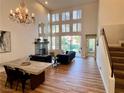 Open-concept living room with a fireplace, high ceilings, and hardwood floors at 4963 Crooked Stick Way, Las Vegas, NV 89113
