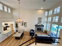 Spacious living room featuring a fireplace, tall windows, and hardwood flooring at 4963 Crooked Stick Way, Las Vegas, NV 89113