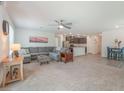 Open-concept living room with carpet, ceiling fan, and view of the kitchen, ideal for modern living at 518 Descubir Ave, North Las Vegas, NV 89081