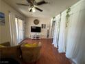 Comfortable living room with ceiling fan, large windows, and a television on a white stand at 5499 Indian River Dr # 356, Las Vegas, NV 89103