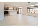 Bright, open-concept living space featuring sleek, tiled floors and abundant natural light from large windows at 5804 Gossamer Stone Ct, Las Vegas, NV 89141