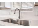 Close-up of the kitchen featuring a stainless steel sink, quartz countertops, and modern faucet fixture at 600 Berry Cir, Las Vegas, NV 89107