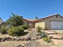 Charming single-story home featuring a rockscaped front yard, mature landscaping, and a two car garage at 6357 Cobalt Ln, Las Vegas, NV 89146