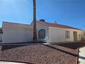 Side view of house featuring neutral stucco and red tile roof, complimented by desert landscaping at 6636 Old Oxford Ave, Las Vegas, NV 89108