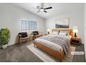 Light-filled main bedroom featuring a ceiling fan, a large window, and neutral carpeting at 6696 Merced Lake Dr, Las Vegas, NV 89156