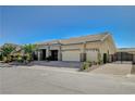 Single story home featuring desert landscaping, stone accents, tile roof, three car garage and gated driveway at 6971 Moaning Cavern St, Las Vegas, NV 89131