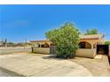 Charming single-story home featuring a gated entrance, lush landscaping and a tan exterior at 744 Mcknight St, Las Vegas, NV 89101