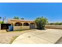 Charming single-story home featuring a gated entrance, lush landscaping and a tan exterior at 744 Mcknight St, Las Vegas, NV 89101