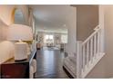 Stylish entryway with hardwood floors, a staircase, and a view into the living room at 7705 Alder Forest St, Las Vegas, NV 89113