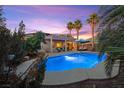 Relaxing backyard oasis featuring a sparkling pool, shaded patio, and lush tropical landscaping at 8623 Kennedy Heights Ct, Las Vegas, NV 89131