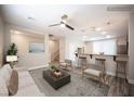 Bright living room featuring an open floor plan, ceiling fan, and bar seating area at 9314 Hopcroft Ave, Las Vegas, NV 89178