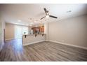 Spacious living room featuring wood-look floors, recessed lighting and an adjacent kitchen area at 9314 Hopcroft Ave, Las Vegas, NV 89178