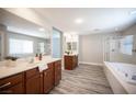 Luxurious bathroom with dual vanities, a soaking tub, glass shower, and modern fixtures at 9314 Hopcroft Ave, Las Vegas, NV 89178