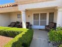 Inviting front porch with seating, lush greenery, and a decorative storm door with welcome mat at 9505 Quail Ridge Dr, Las Vegas, NV 89134