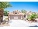 Attractive single-story home featuring desert landscaping, mature palm trees, and a two-car garage at 9632 Spanish Steps Ln, Las Vegas, NV 89117