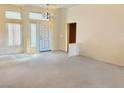Spacious living room featuring plush carpet flooring, neutral walls, and an entry door with stained glass windows at 3028 Ripon Dr, Las Vegas, NV 89134