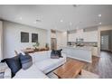 Open-concept living area with a sofa, dining table, and a sleek, modern kitchen at 3358 Via Strada St, Henderson, NV 89044