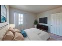 Cozy bedroom featuring a plush bed, large window, and a sleek entertainment center at 4990 River Glen Dr # 171, Las Vegas, NV 89103