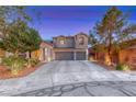 Beautifully landscaped two-story home with a three-car garage and a spacious driveway at 53 Precipice Ct, Henderson, NV 89002