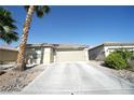 Single-story home features a two-car garage, desert landscaping, and paved driveway at 6040 Eganridge Ct, North Las Vegas, NV 89081