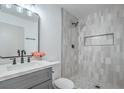 Well-lit bathroom features gray and white tiling and includes vanity and glass-enclosed shower at 6517 Villa Mesa Dr, Las Vegas, NV 89107