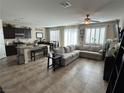 Open-concept living space with a large sectional couch and modern finishes at 6682 Salt Pond Bay St, Las Vegas, NV 89149