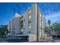 A twilight view of the condo building, highlighting its structure and landscaping with warm interior lights at 745 N Royal Crest Cir # 157, Las Vegas, NV 89169