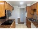 Traditional kitchen features wooden cabinets, tiled countertops and backsplash, and stainless steel microwave at 745 N Royal Crest Cir # 157, Las Vegas, NV 89169
