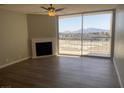Bright living room with wood floors, fireplace, ceiling fan, and sliding glass doors at 745 N Royal Crest Cir # 157, Las Vegas, NV 89169