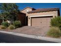 Attractive single-story home with desert landscaping, a brick driveway, and a two-car garage at 832 Gallery Course Dr, Las Vegas, NV 89148