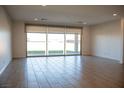 Open living room with tile flooring, recessed lighting, and large windows providing natural light and backyard views at 832 Gallery Course Dr, Las Vegas, NV 89148