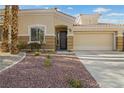 Exterior of home features a desert-style yard, two-car garage, and well-maintained landscaping at 9256 Blue Flax Pl, Las Vegas, NV 89148