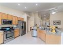 Bright kitchen features stainless steel appliances, a kitchen island, and light wood cabinets at 9256 Blue Flax Pl, Las Vegas, NV 89148