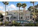 Luxury two-story home showcasing a pool, meticulously landscaped yard, and rows of palm trees at 9408 Players Canyon Ct, Las Vegas, NV 89144