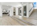 Bright and airy foyer with hardwood floors, a staircase, and modern finishes at 9408 Players Canyon Ct, Las Vegas, NV 89144